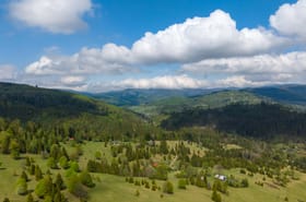 Panorama zielonych wzgórz Beskidów pod chmurami — okolica domków pod Muńcołem na wypoczynek.